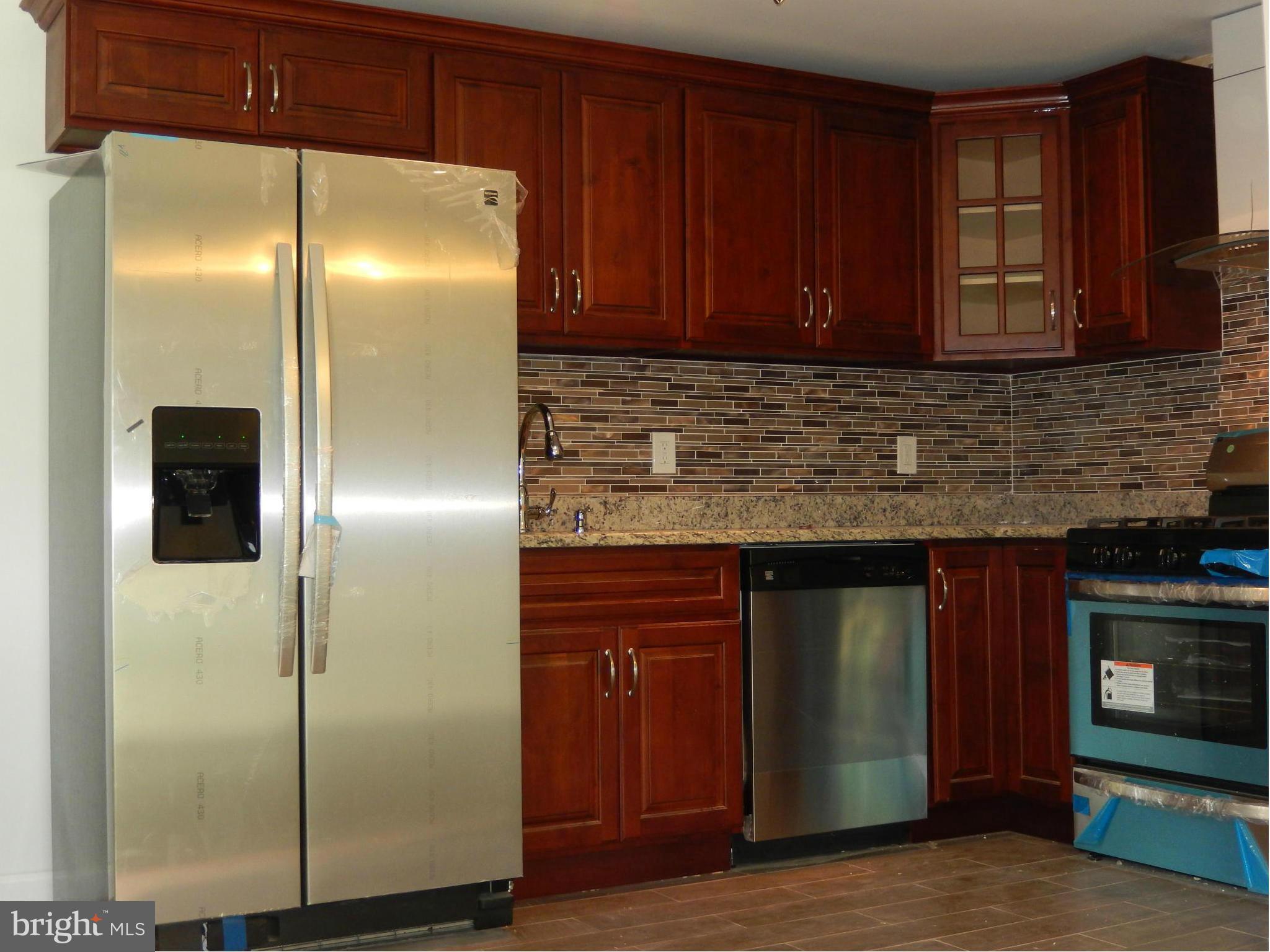 4301 Cedar Garden Road Baltimore, MD 21229 - Photo 21 of 29 a kitchen with stainless steel appliances granite countertop a refrigerator and a sink