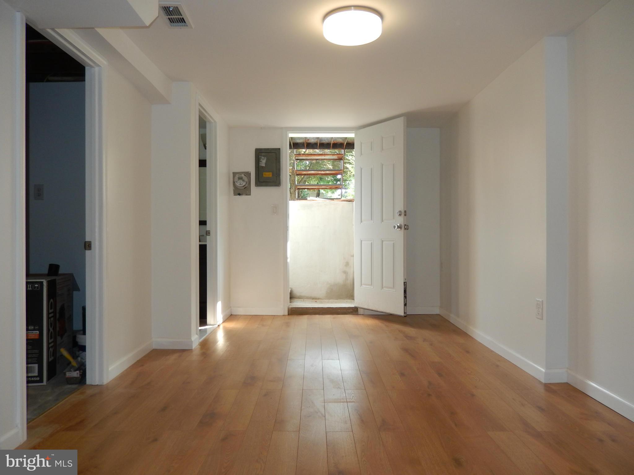 4301 Cedar Garden Road Baltimore, MD 21229 - Photo 26 of 29 a view of an empty room with wooden floor and a window