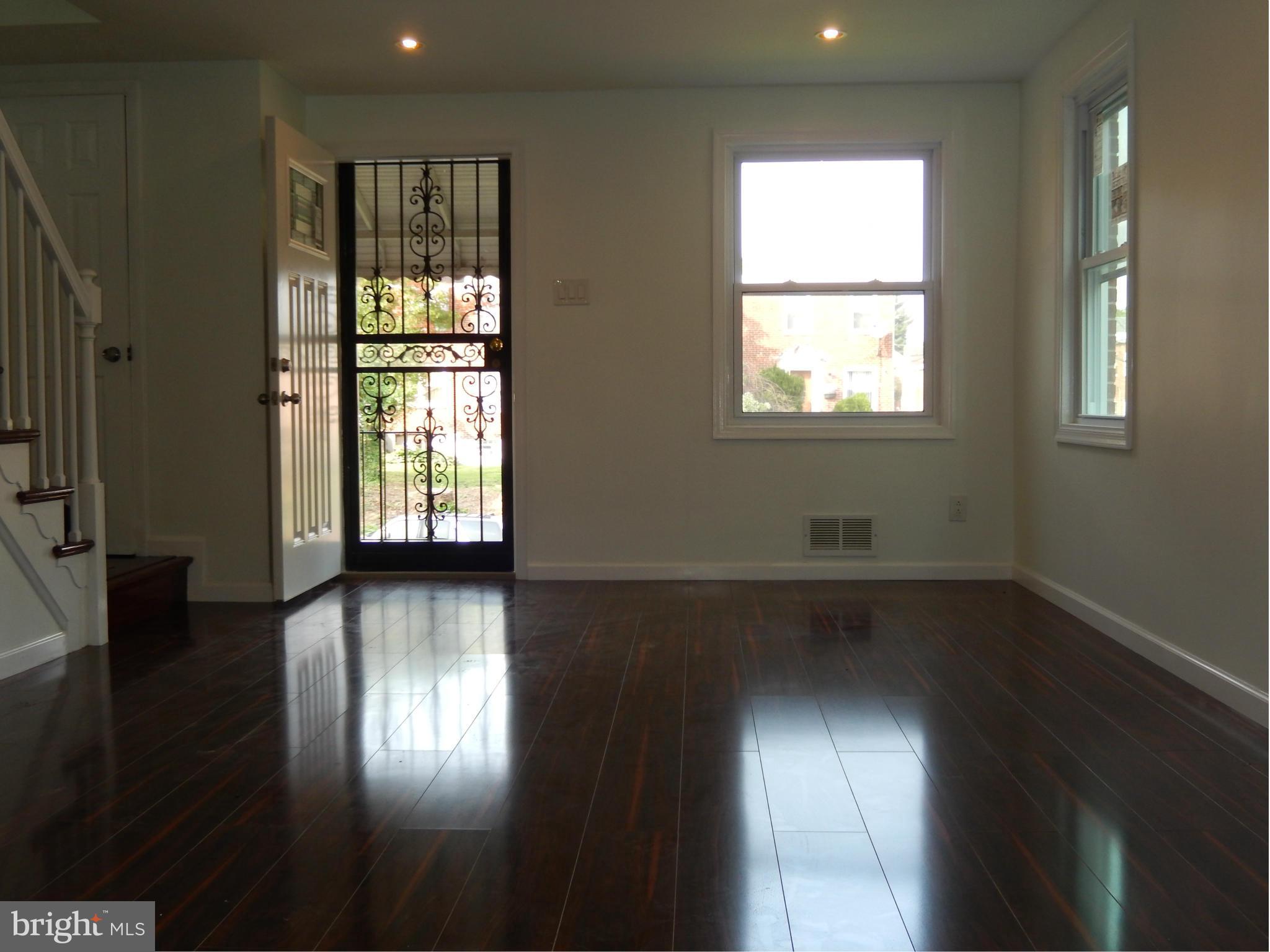4301 Cedar Garden Road Baltimore, MD 21229 - Photo 5 of 29 a view of an empty room with wooden floor and a window
