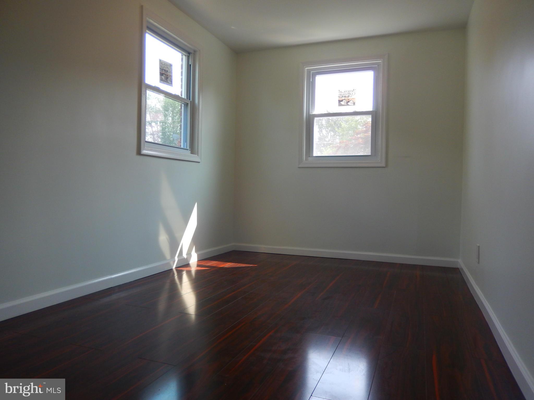 4301 Cedar Garden Road Baltimore, MD 21229 - Photo 9 of 29 an empty room with wooden floor and windows