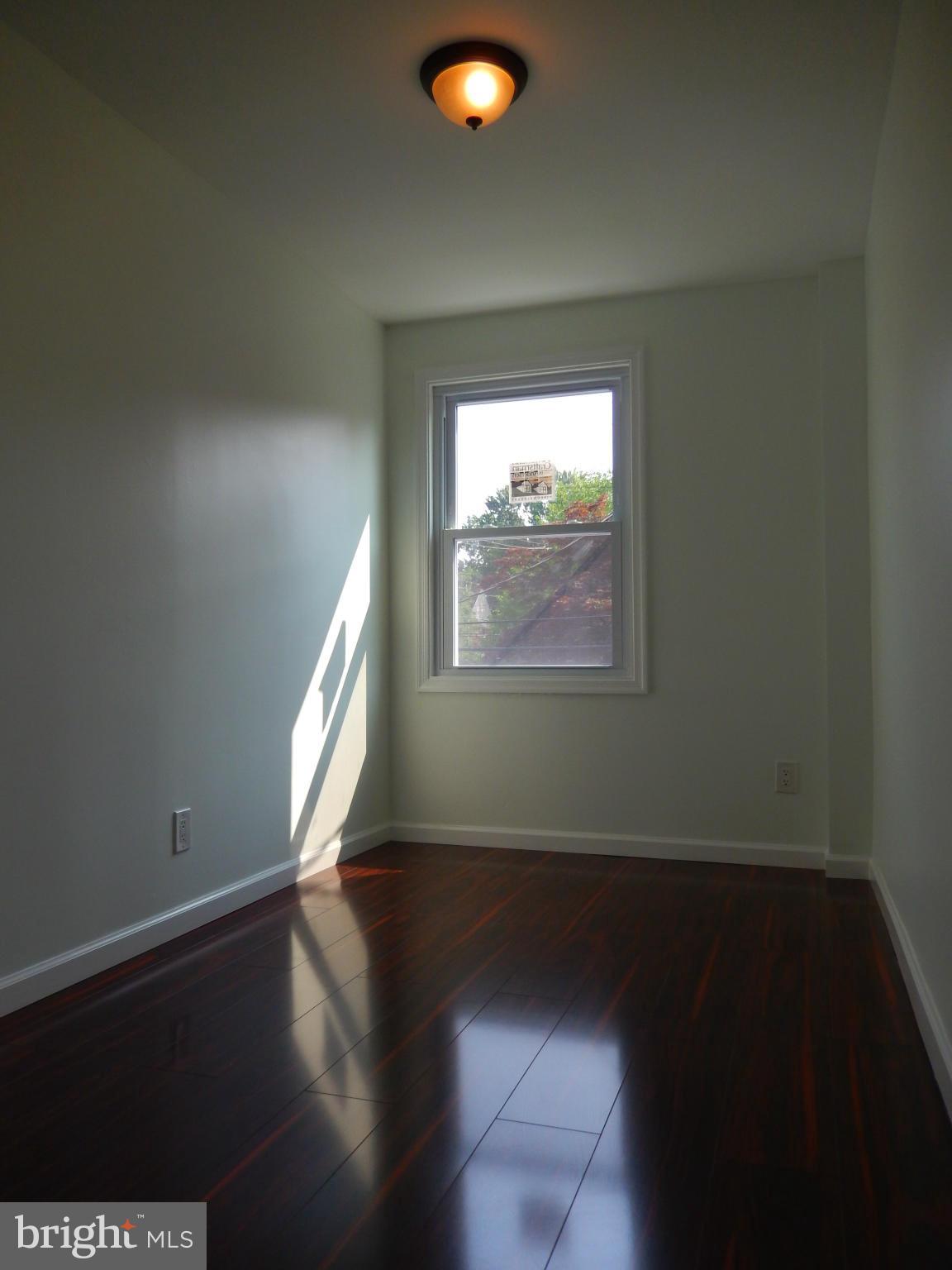 4301 Cedar Garden Road Baltimore, MD 21229 - Photo 10 of 29 a view of an empty room with wooden floor and a window