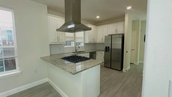 a kitchen with stainless steel appliances a refrigerator a stove a table and chairs