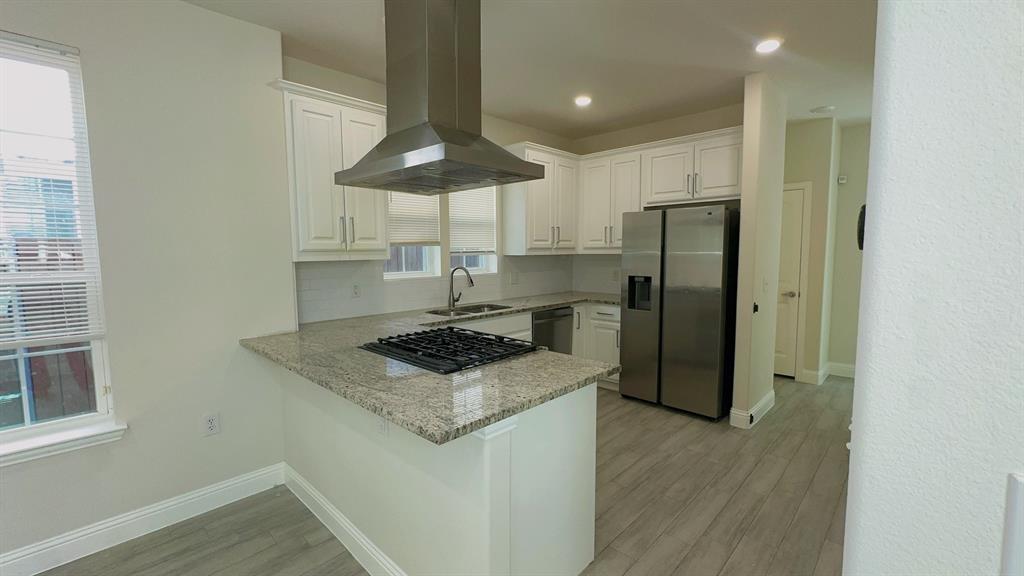 2239 Anderson Street Dallas, TX 75215 - Photo 3 of 16 a kitchen with stainless steel appliances a refrigerator a stove a table and chairs