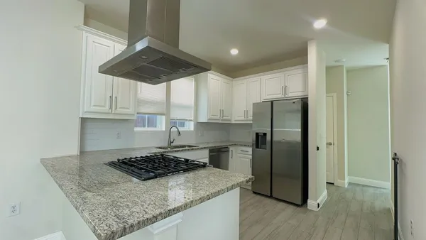 a kitchen with a stove a refrigerator and a cabinets