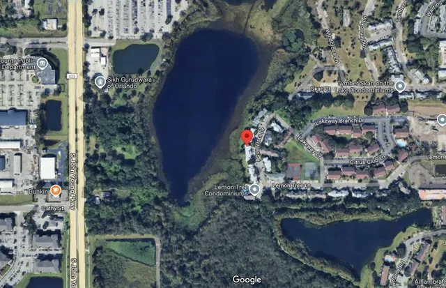 an aerial view of a houses with a yard and lake view