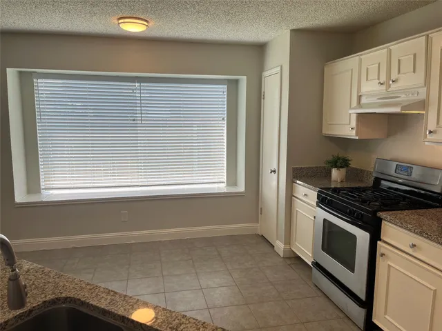 a kitchen with windows and cabinets
