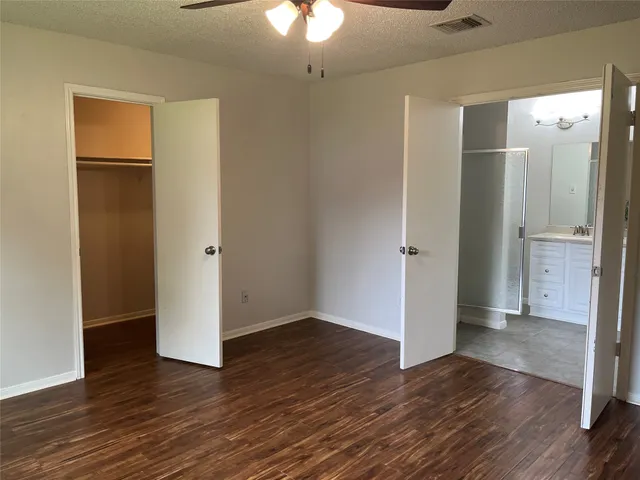 an empty room with wooden floor and a bathroom