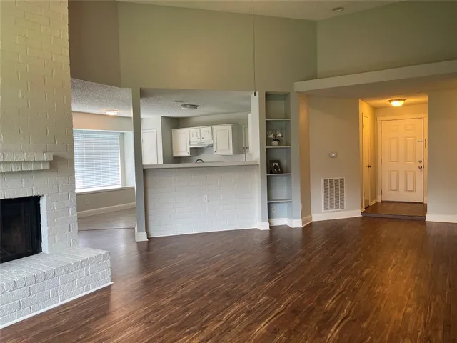 a view of a big room with wooden floor and fire place