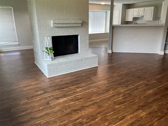 a living room with wooden floors and a fireplace