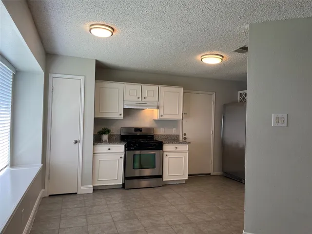 a kitchen with stainless steel appliances granite countertop a stove a refrigerator and a sink