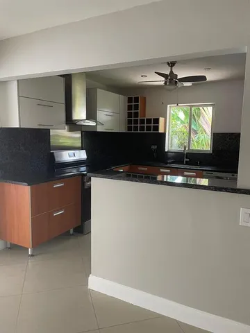 a kitchen with stainless steel appliances granite countertop a sink a stove top oven a counter space and cabinets