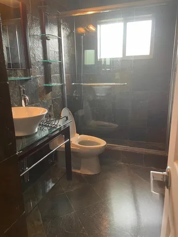 a bathroom with a granite countertop sink a toilet and a mirror