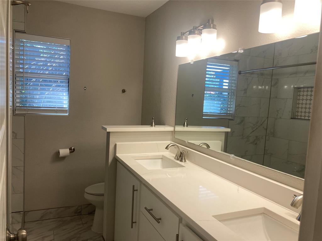 518 Burnwood Drive Irving, TX 75062 - Photo 11 of 18 a bathroom with a sink toilet and shower