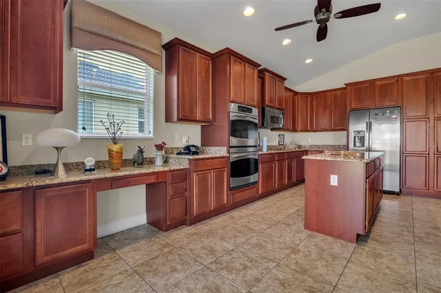 a kitchen with stainless steel appliances granite countertop a stove refrigerator sink and cabinets