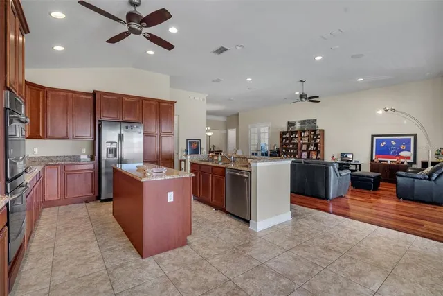 a kitchen with stainless steel appliances granite countertop a stove refrigerator sink and cabinets