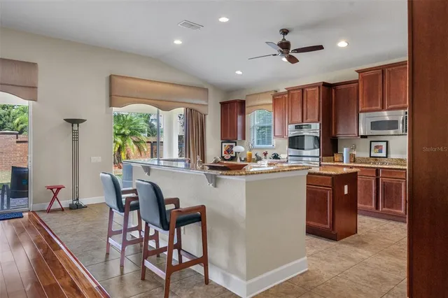 a kitchen with kitchen island granite countertop wooden floors appliances and furniture
