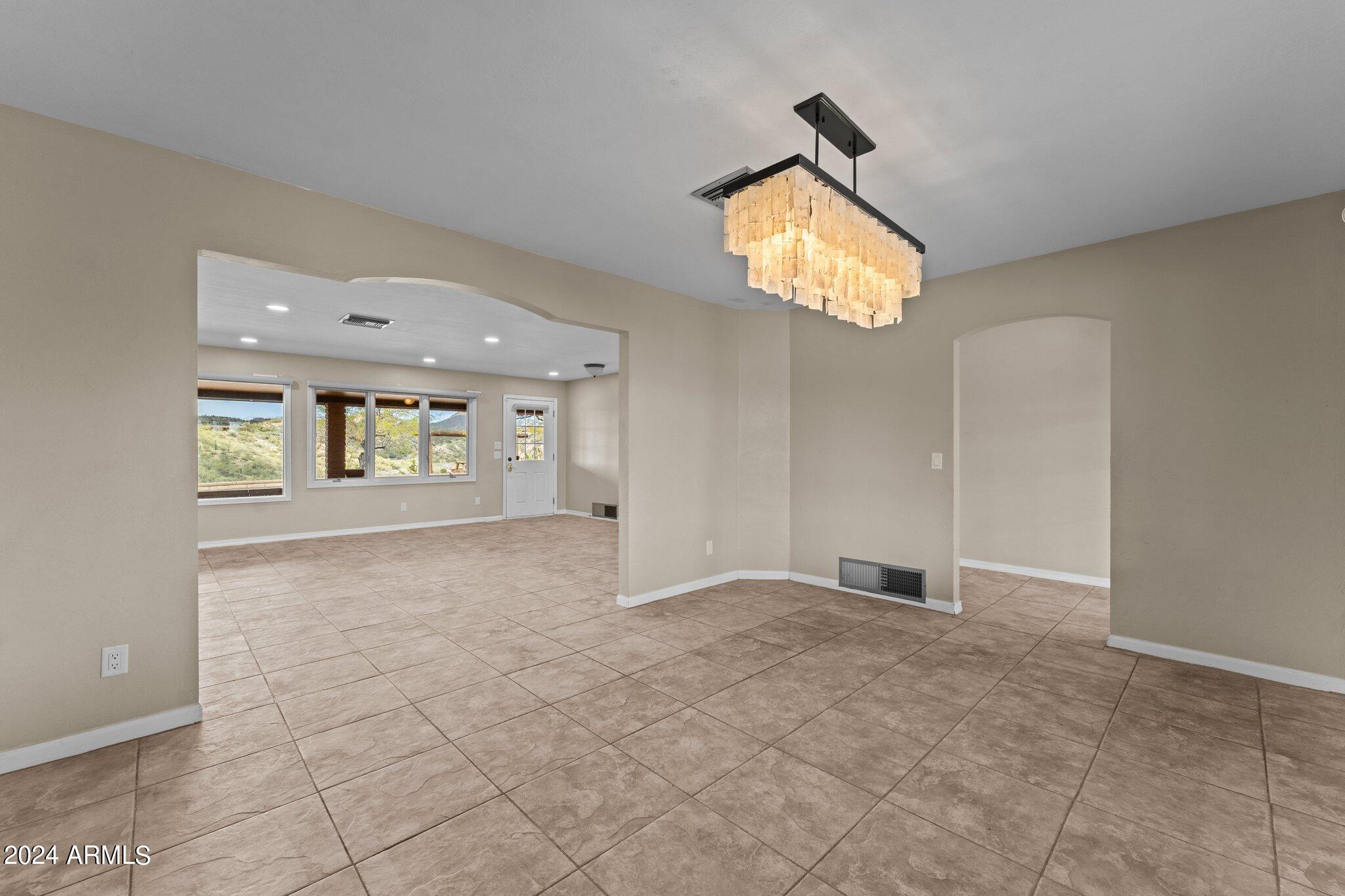 1605 North Little Stonehedge Ranch Road Wickenburg, AZ 85390 - Photo 16 of 54 an empty room with windows and fireplace