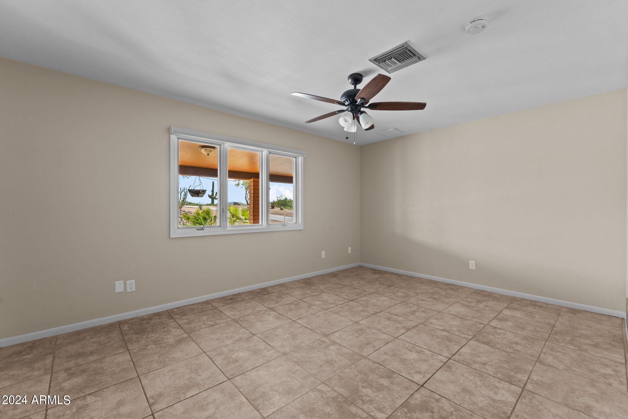 1605 North Little Stonehedge Ranch Road Wickenburg, AZ 85390 - Photo 18 of 54 an empty room with windows and ceiling fan