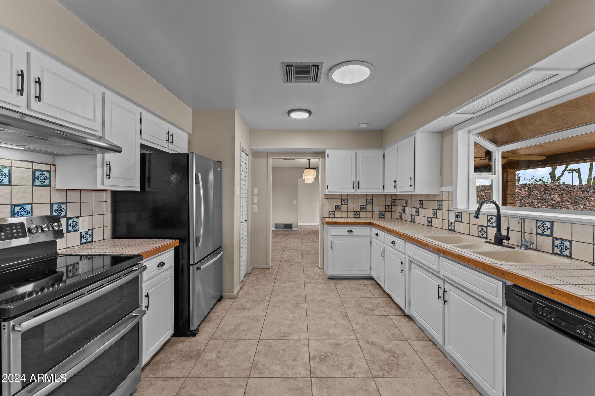 1605 North Little Stonehedge Ranch Road Wickenburg, AZ 85390 - Photo 2 of 54 a large kitchen with a large window and stainless steel appliances