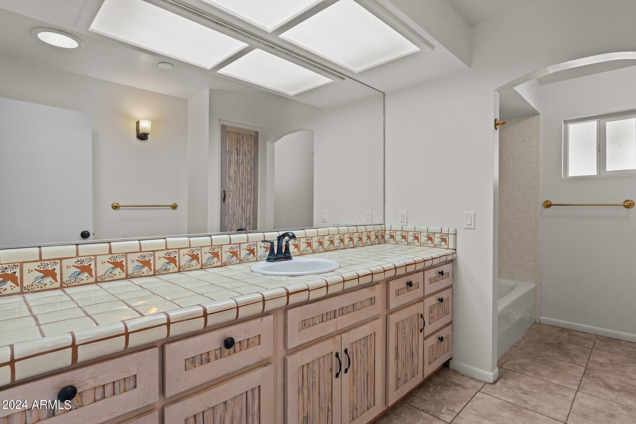 1605 North Little Stonehedge Ranch Road Wickenburg, AZ 85390 - Photo 24 of 54 a bathroom with a granite countertop sink and a mirror