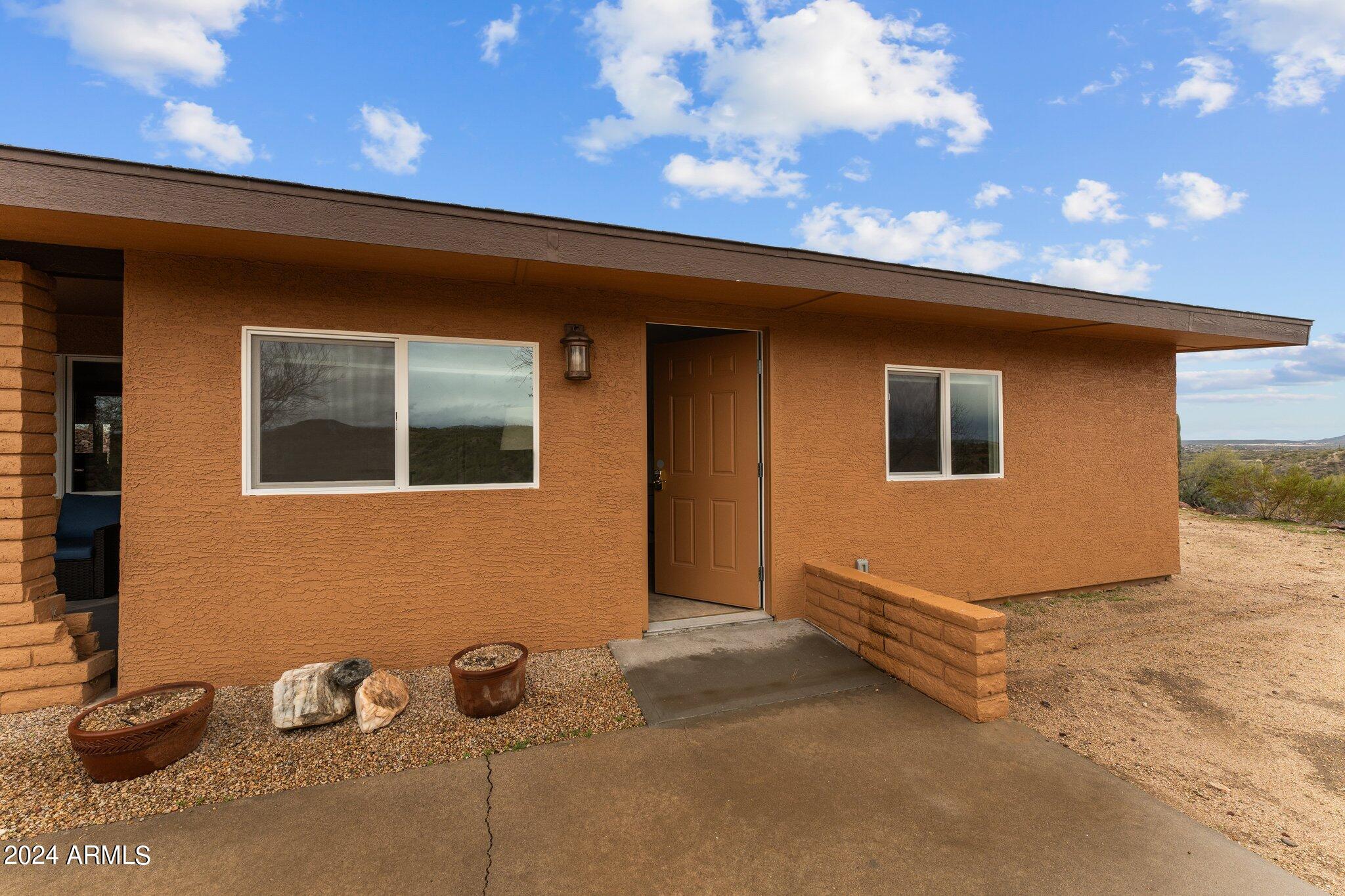 1605 North Little Stonehedge Ranch Road Wickenburg, AZ 85390 - Photo 26 of 54 a backyard of a house with potted plants