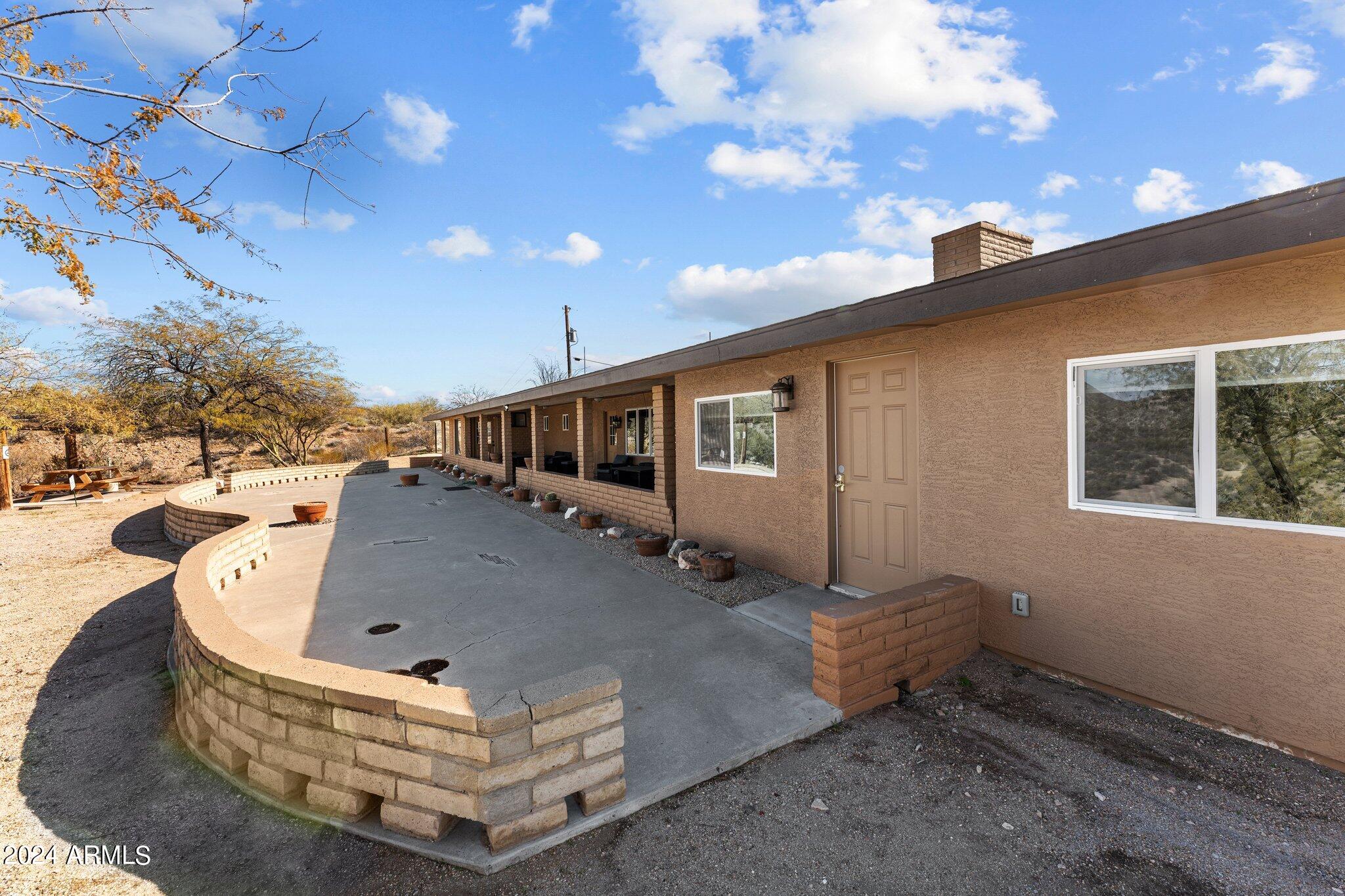 1605 North Little Stonehedge Ranch Road Wickenburg, AZ 85390 - Photo 35 of 54 a roof deck with table and chairs with wooden floor and fence