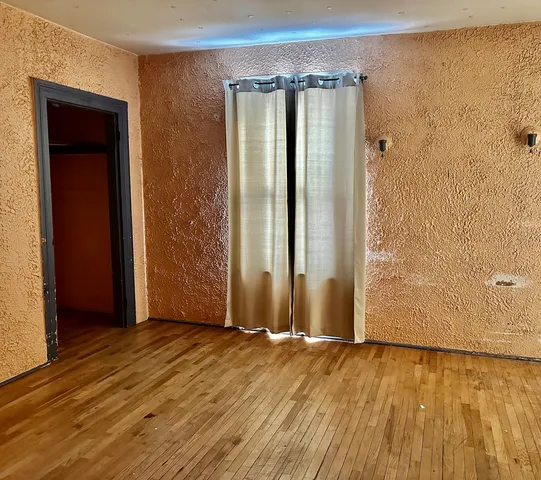 an empty room with wooden floor and a window