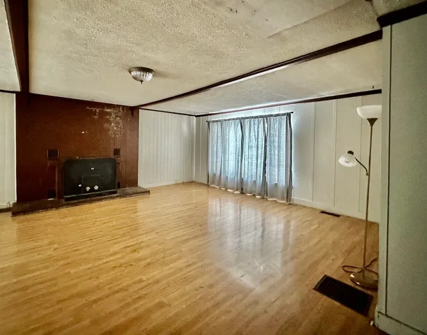en empty room with wooden floor and windows