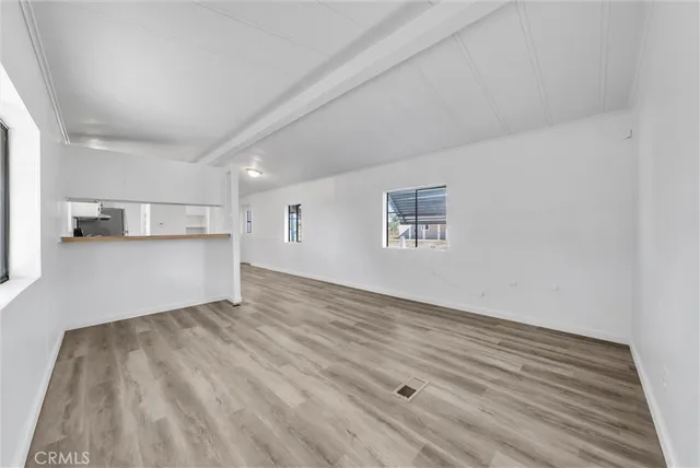 a view of a big room with wooden floor and windows