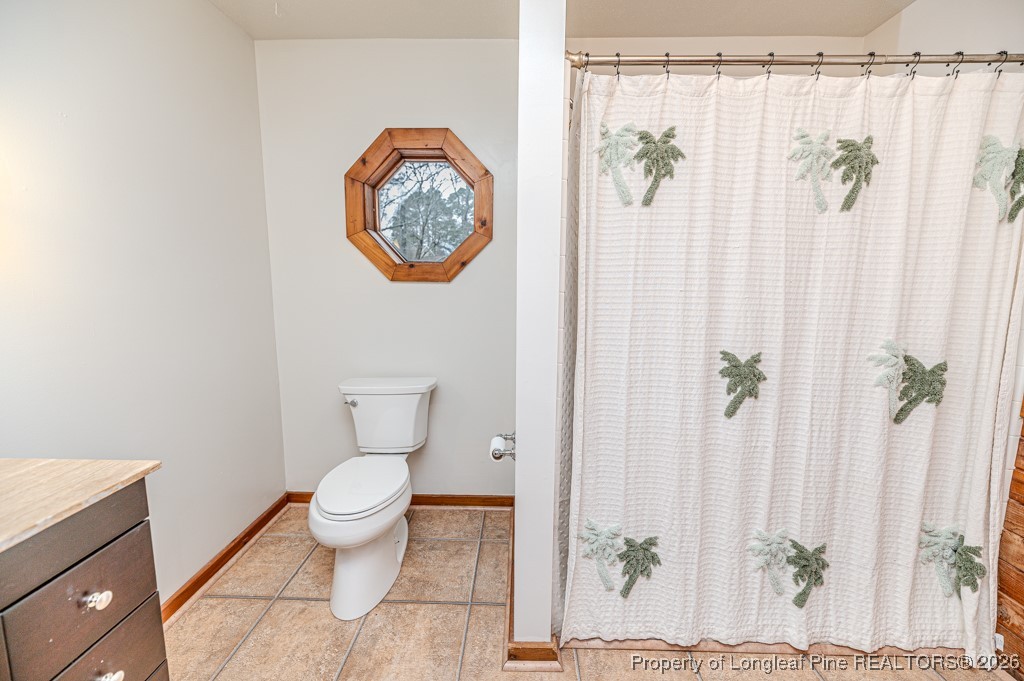 515 Tramway West Road Sanford, NC 27330 - Photo 28 of 38 a bathroom with a toilet and a shower curtain