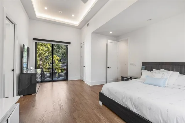 a bedroom with a balcony a bed and wooden floor