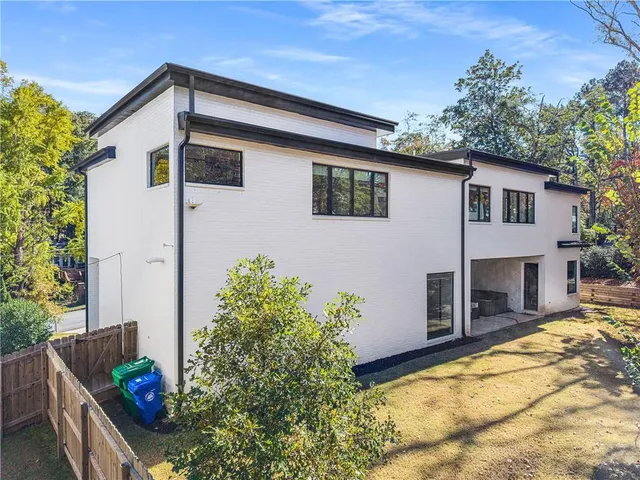 a view of a house with a small yard and large tree
