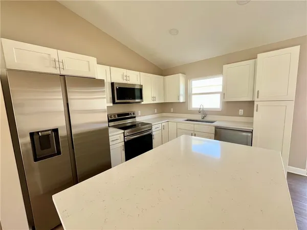 a kitchen with a refrigerator a stove top oven a sink and dishwasher