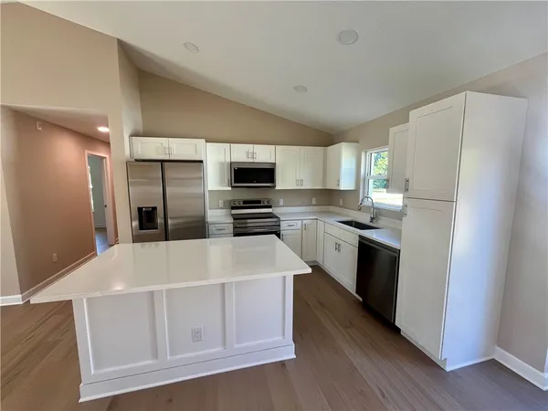 a kitchen with stainless steel appliances a refrigerator sink and microwave