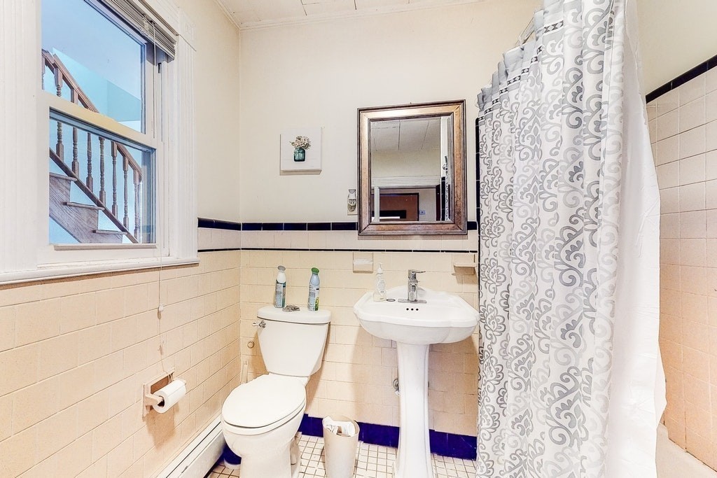 8-10 Allston Street Newton, MA 02465 - Photo 25 of 42 a bathroom with a sink a toilet and a mirror