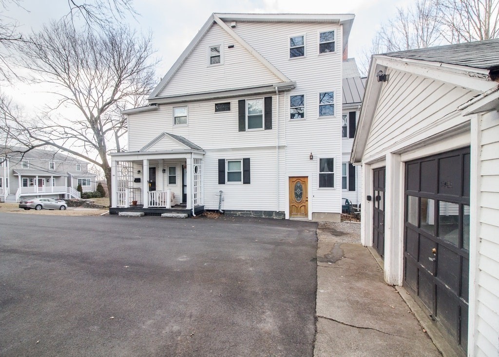 8-10 Allston Street Newton, MA 02465 - Photo 4 of 42 a front view of a house with a yard and garage