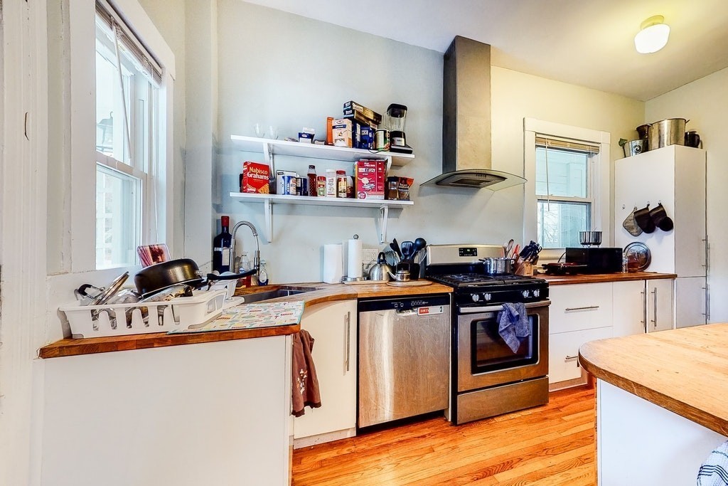 8-10 Allston Street Newton, MA 02465 - Photo 6 of 42 a kitchen with stainless steel appliances granite countertop a sink stove and cabinets