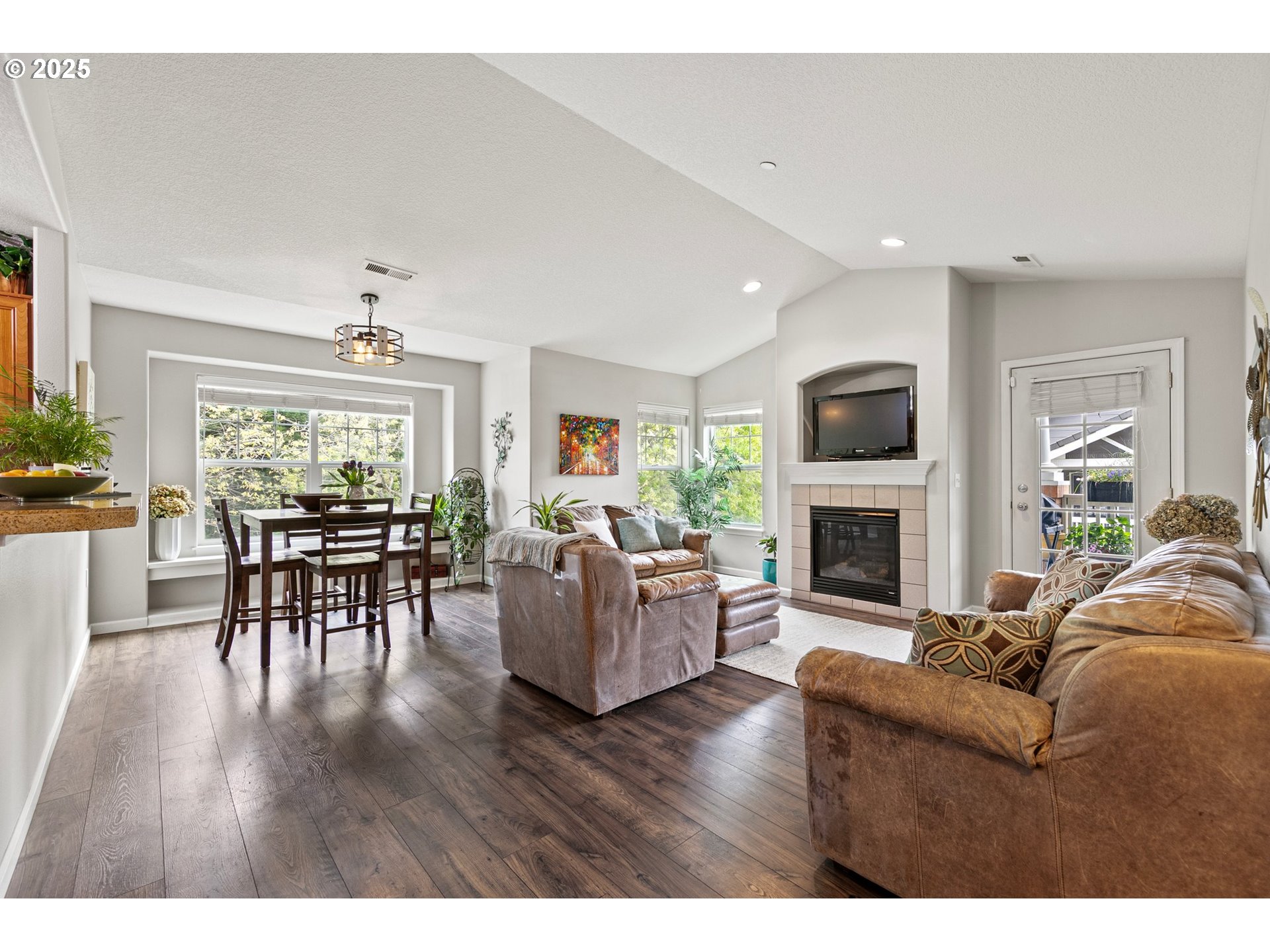 30366 Southwest Ruth Street, Unit 70 Wilsonville, OR 97070 - Photo 10 of 46 a living room with furniture a fireplace and a dining table with wooden floor