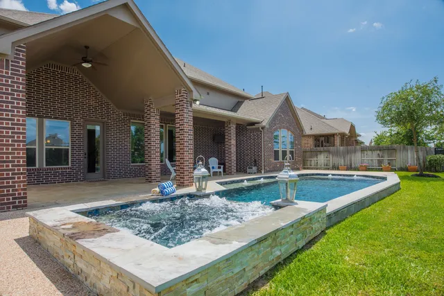 a view of a house with swimming pool and sitting area