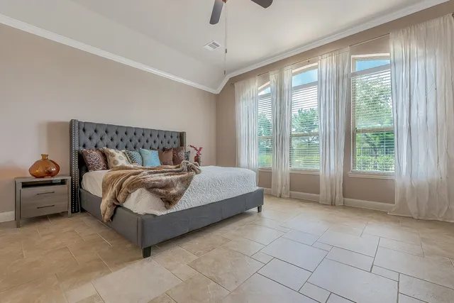 a bedroom with a bed and large windows