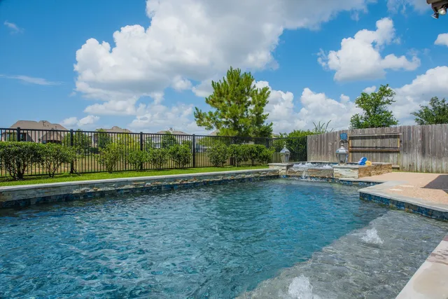 a view of a swimming pool with a yard and sitting area