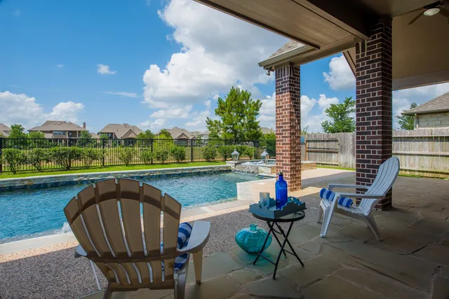 a swimming pool with outdoor seating and yard