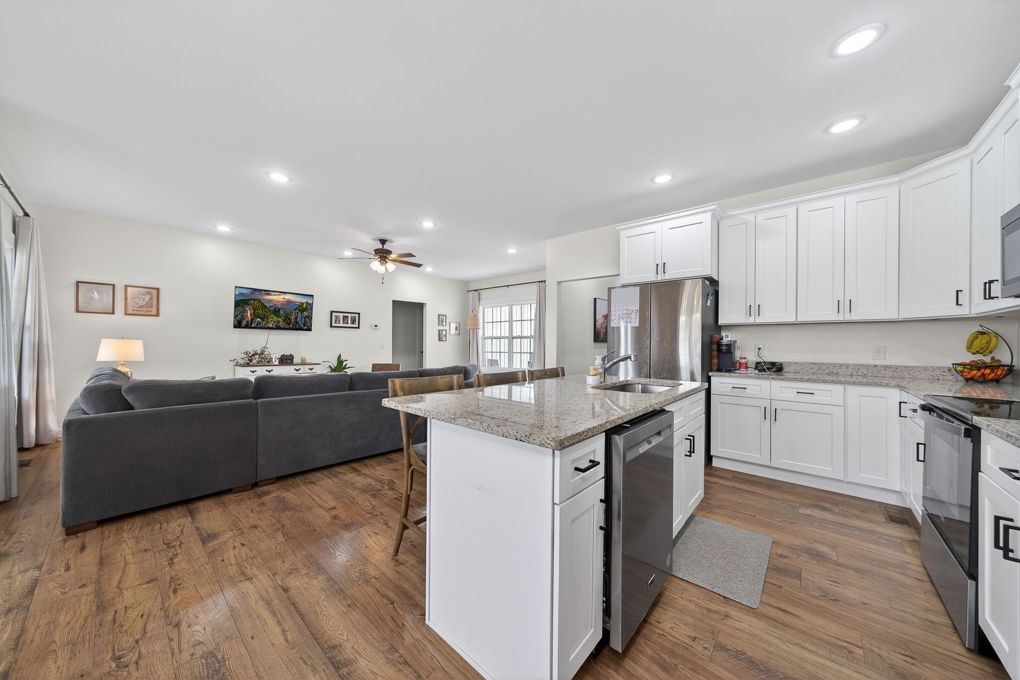 652 Clog Valley Road Sparta, TN 38583 - Photo 7 of 38 a kitchen with stainless steel appliances granite countertop a stove top oven a sink a refrigerator and white cabinets with wooden floor