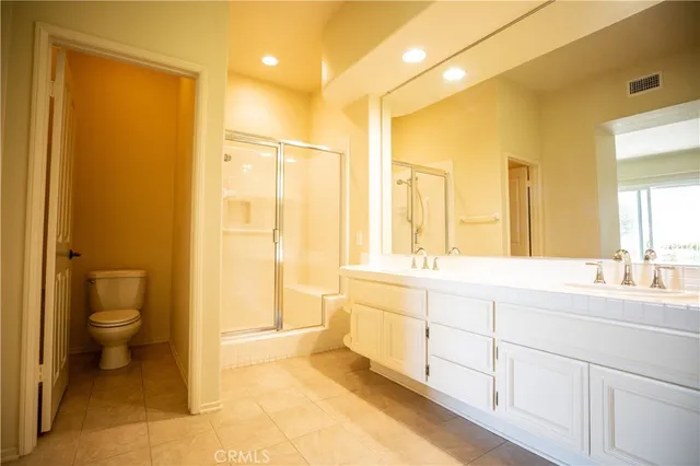 a spacious bathroom with a double vanity sink toilet and a shower