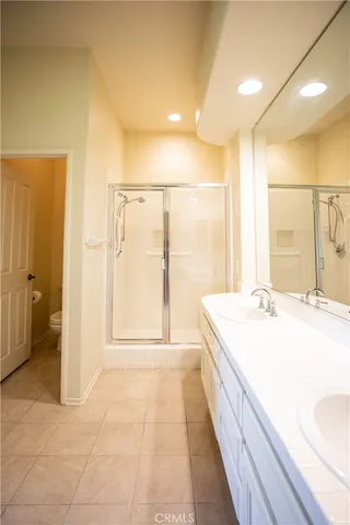a spacious bathroom with a double vanity sink and a large mirror