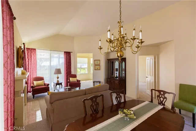 a living room with furniture a chandelier and a dining table