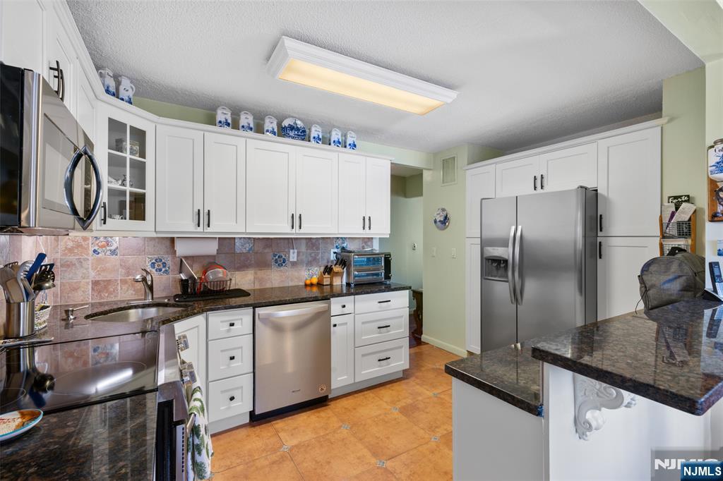 151 Prospect Avenue, Unit 9D Hackensack, NJ 07601 - Photo 12 of 38 a kitchen with granite countertop a sink stainless steel appliances and cabinets