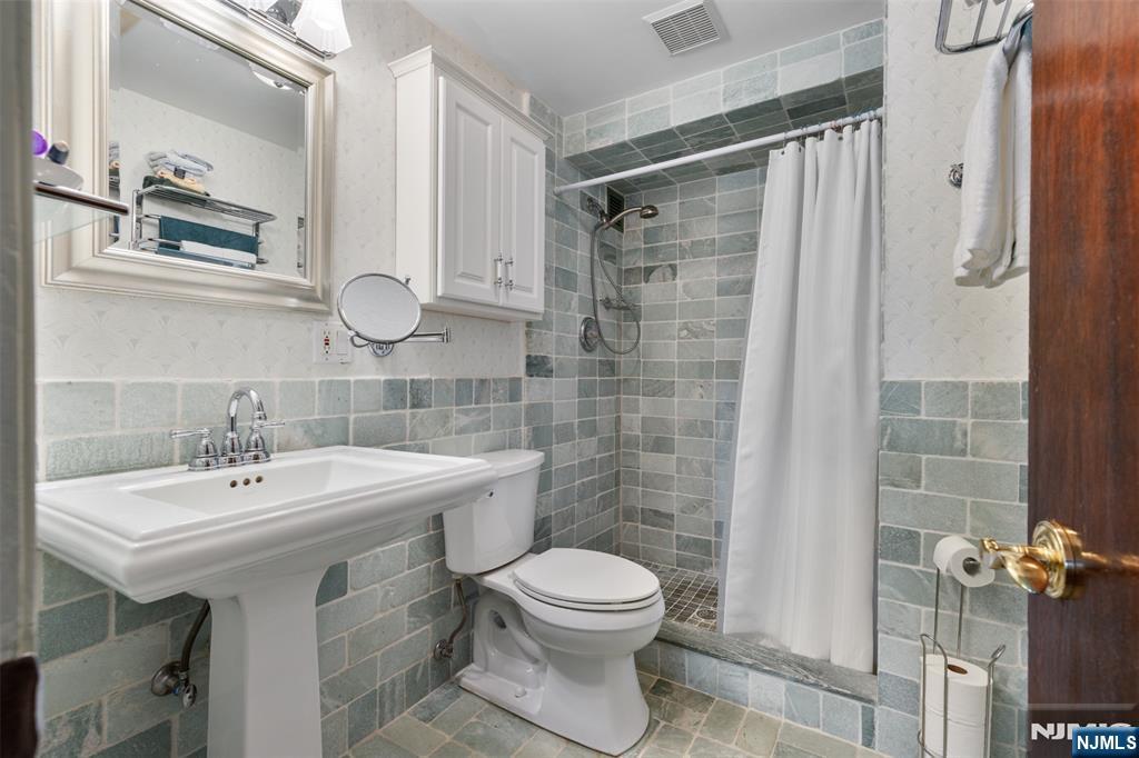 151 Prospect Avenue, Unit 9D Hackensack, NJ 07601 - Photo 17 of 38 a bathroom with a sink toilet and shower