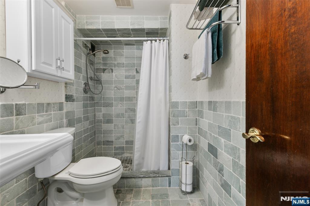 151 Prospect Avenue, Unit 9D Hackensack, NJ 07601 - Photo 18 of 38 a bathroom with a toilet and shower