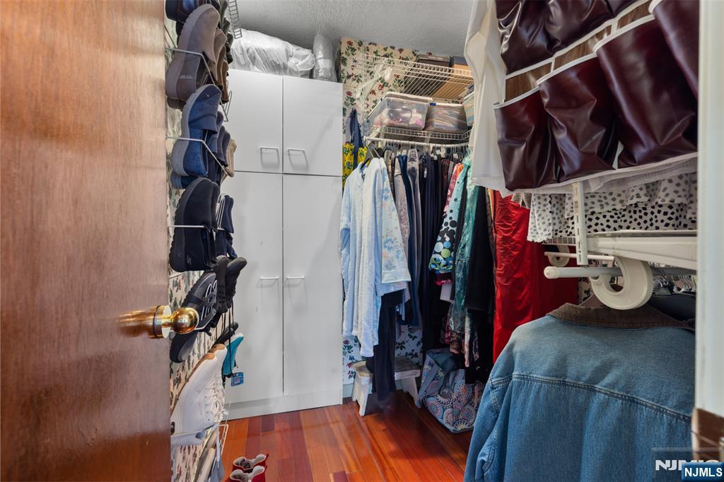 151 Prospect Avenue, Unit 9D Hackensack, NJ 07601 - Photo 19 of 38 a view of walk in closet with clothes and shoes